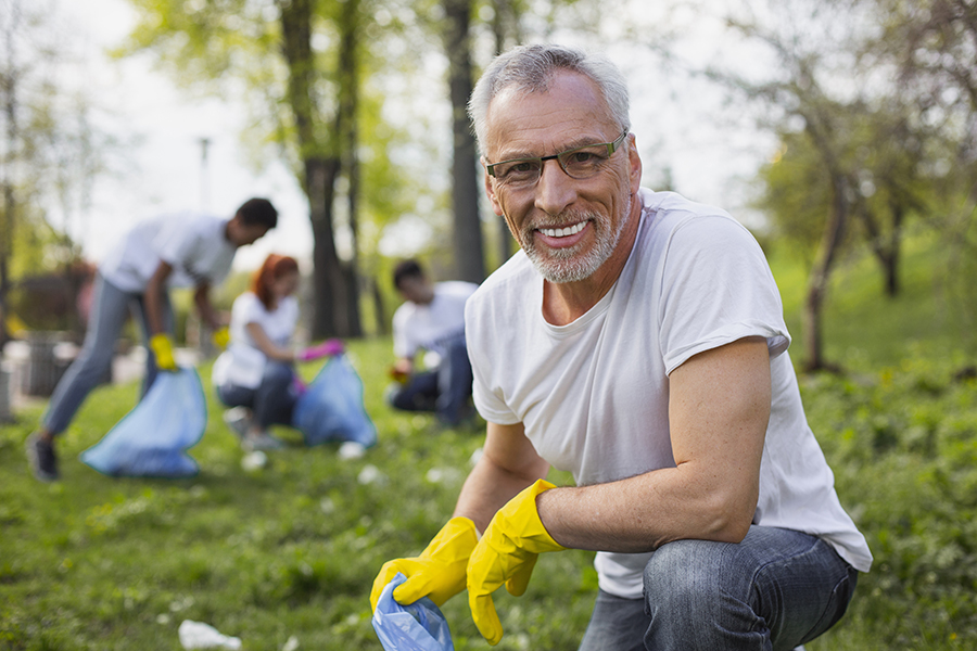 Pleasant senior volunteer getting rid of trash